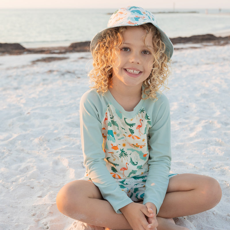 A smiling child wearing the Explore Florida sun hat, showing the wide brim designed to shade the face from the sun.