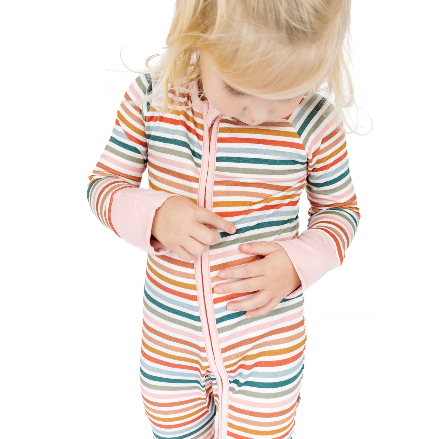 Child wearing a colorful striped onesie on a white background