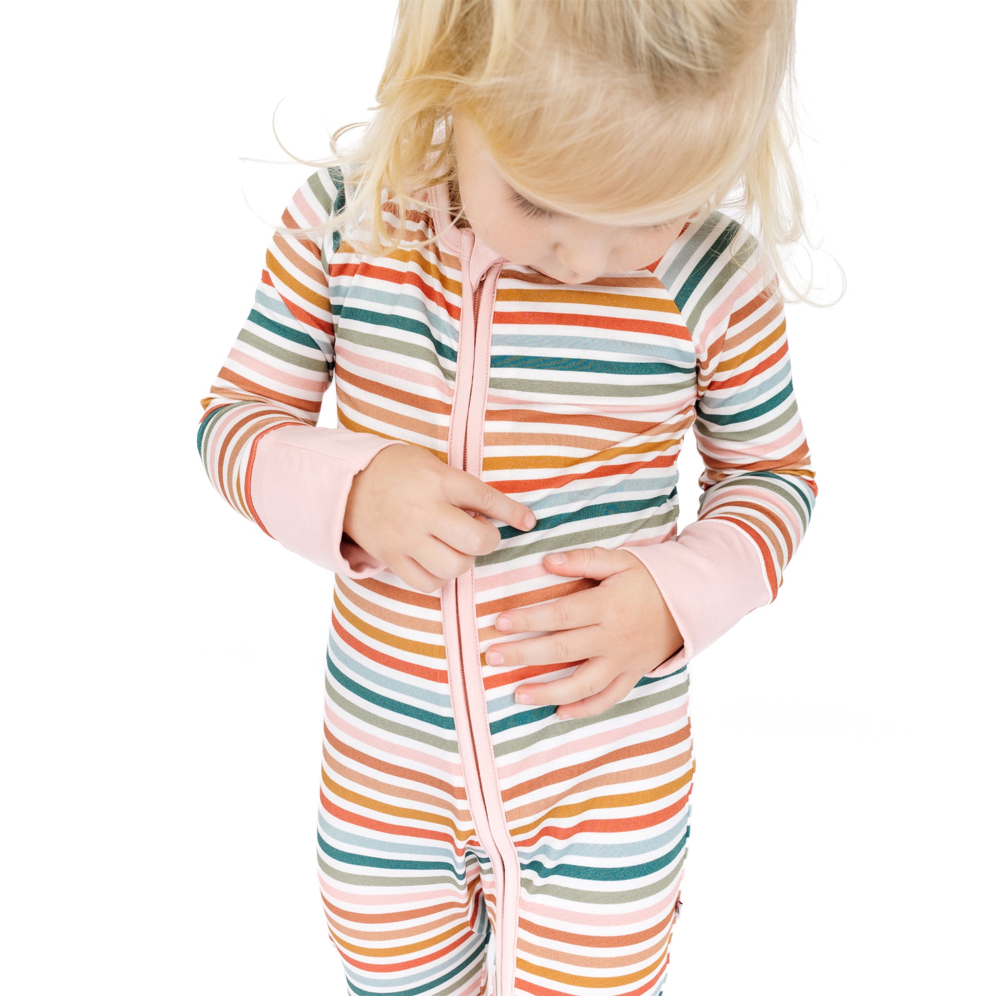 Child wearing a colorful striped onesie on a white background