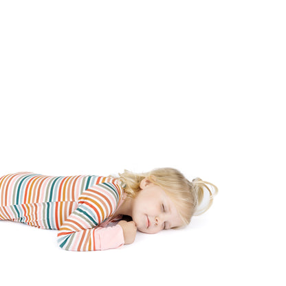 Child sleeping on a white background wearing a striped outfit