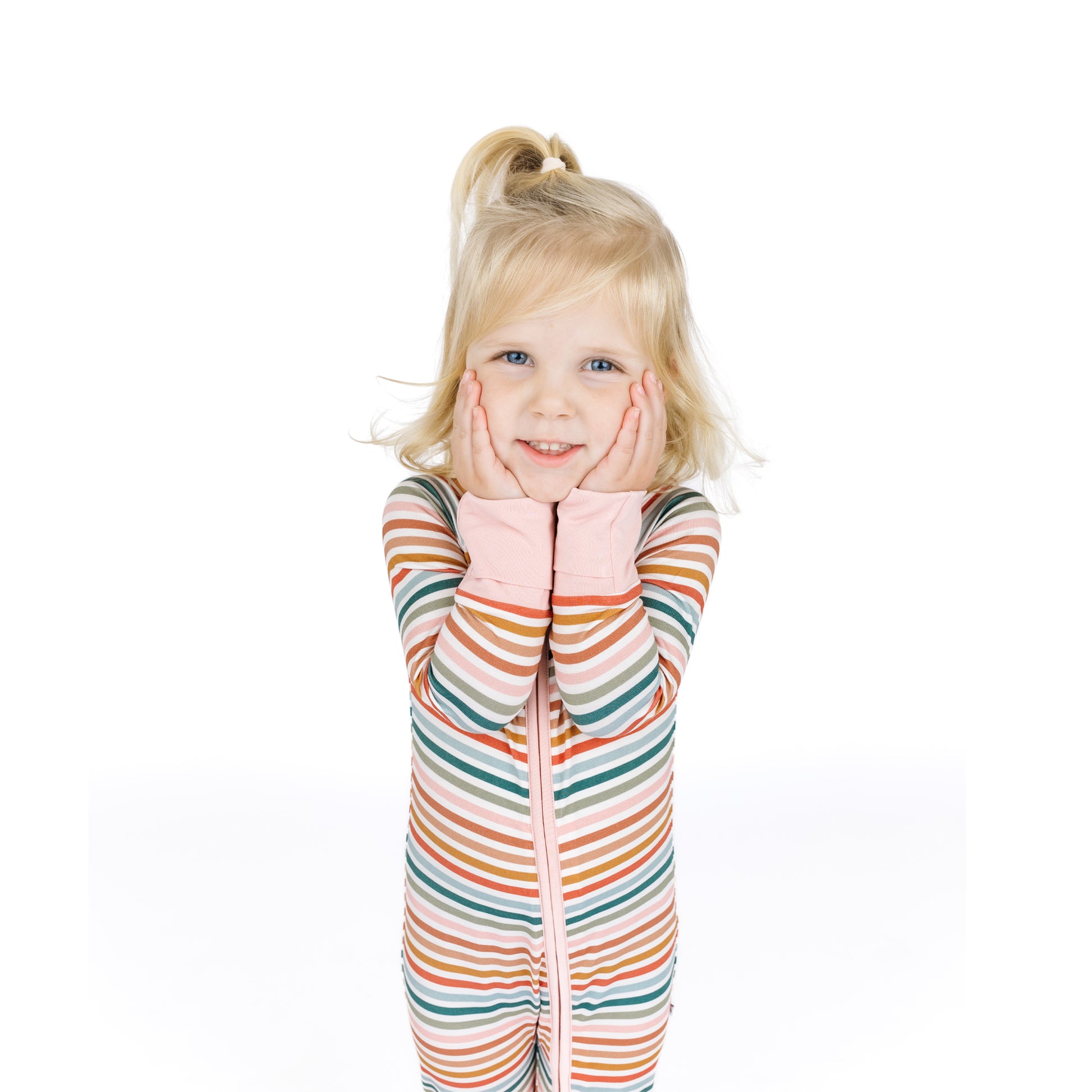 Child wearing a colorful striped onesie on a white background