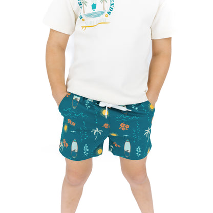 Boy wearing Surf’s Up swim trunks with white graphic tee