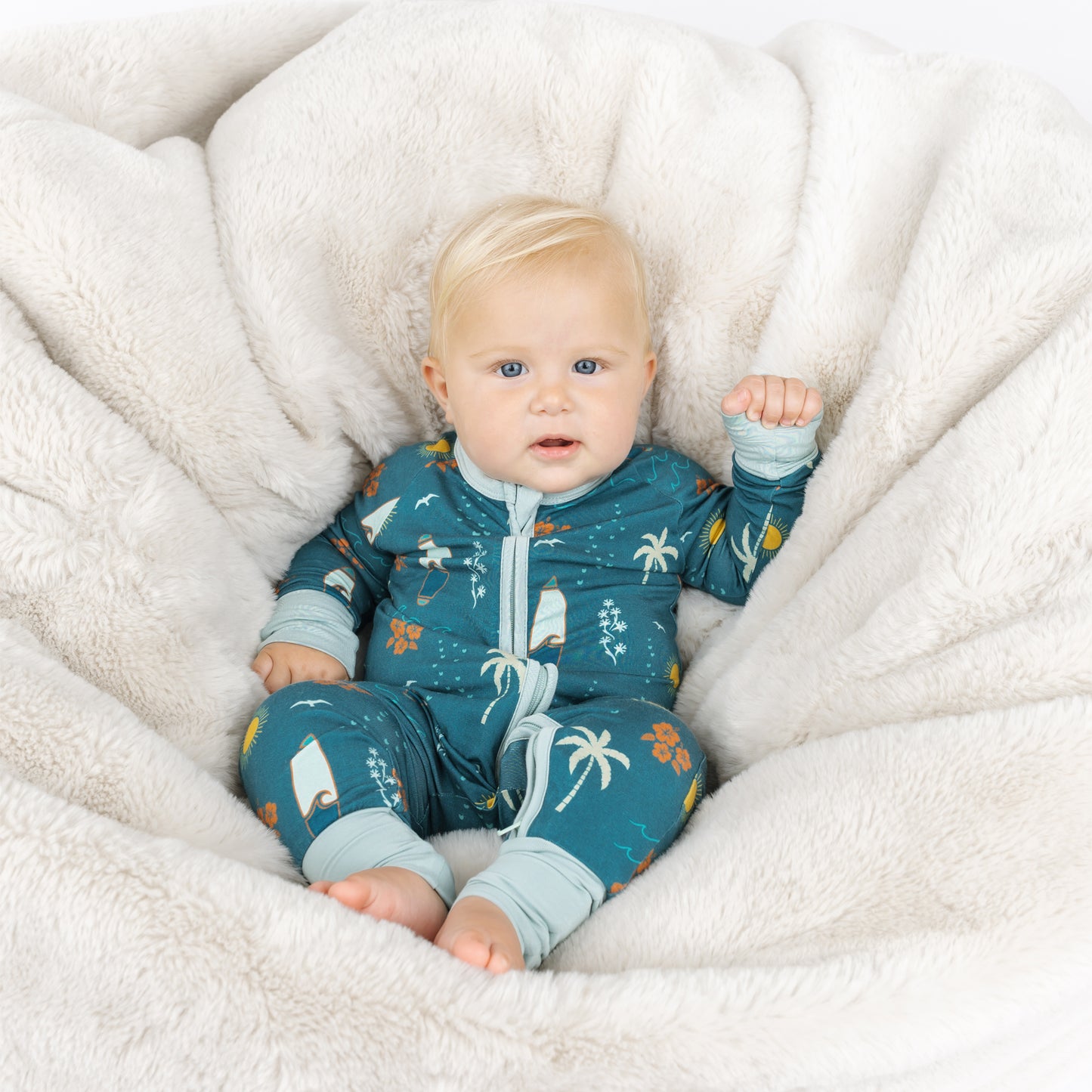 Baby sitting in Surf’s Up bamboo footless pajamas