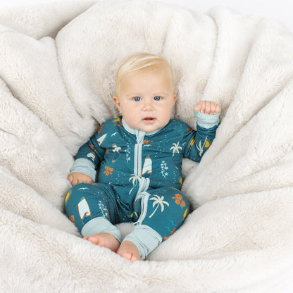 Baby sitting in Surf’s Up bamboo footless pajamas