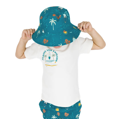 Child wearing Surf’s Up bucket hat playfully covering face