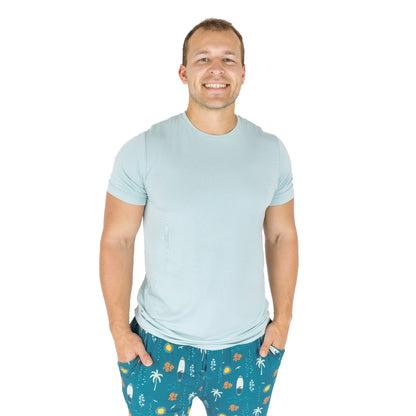 Man wearing Surf’s Up bamboo pajama pants with light blue shirt