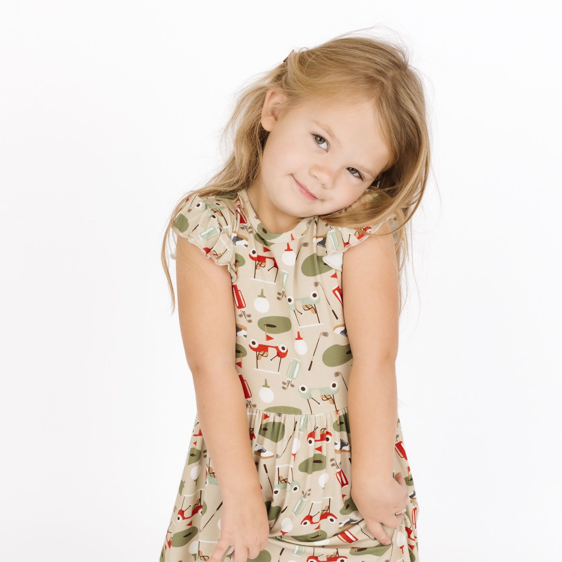 Young girl wearing a patterned dress on a white background