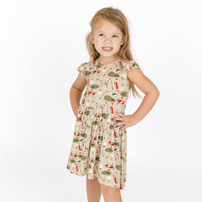 Young girl wearing a patterned dress on a white background