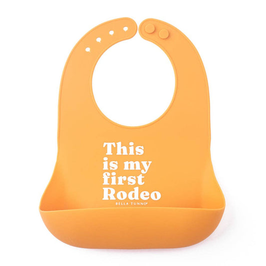 orange silicone bib that reads this is my first rodeo