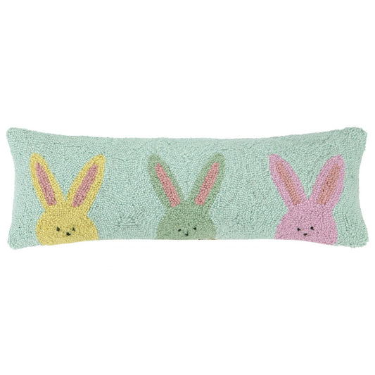 teal pillow with yellow, green, and pink bunnies