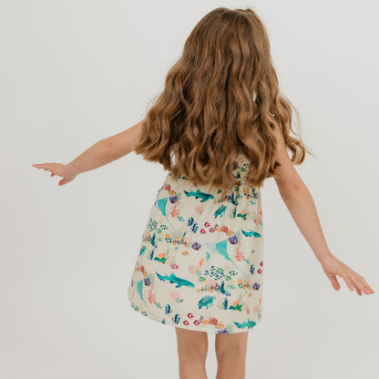 Girl spiraling in our Emerson and Friends Coral Reef Bamboo Sundress featuring an ocean-inspired print with sharks, sea turtles, and coral, made from ultra-soft and breathable bamboo fabric for a lightweight and comfortable summer outfit.