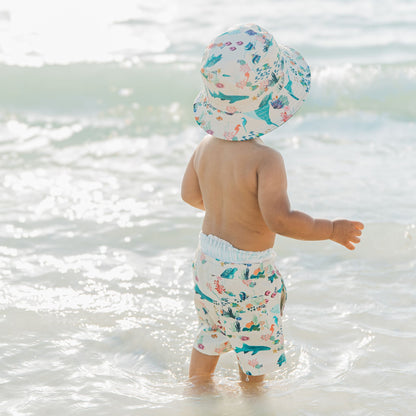 Child wearing a Coral Reef Reversible Bucket Hat with ocean-inspired prints on both sides, offering soft, breathable comfort and UPF 50+ sun protection for all-day outdoor play.