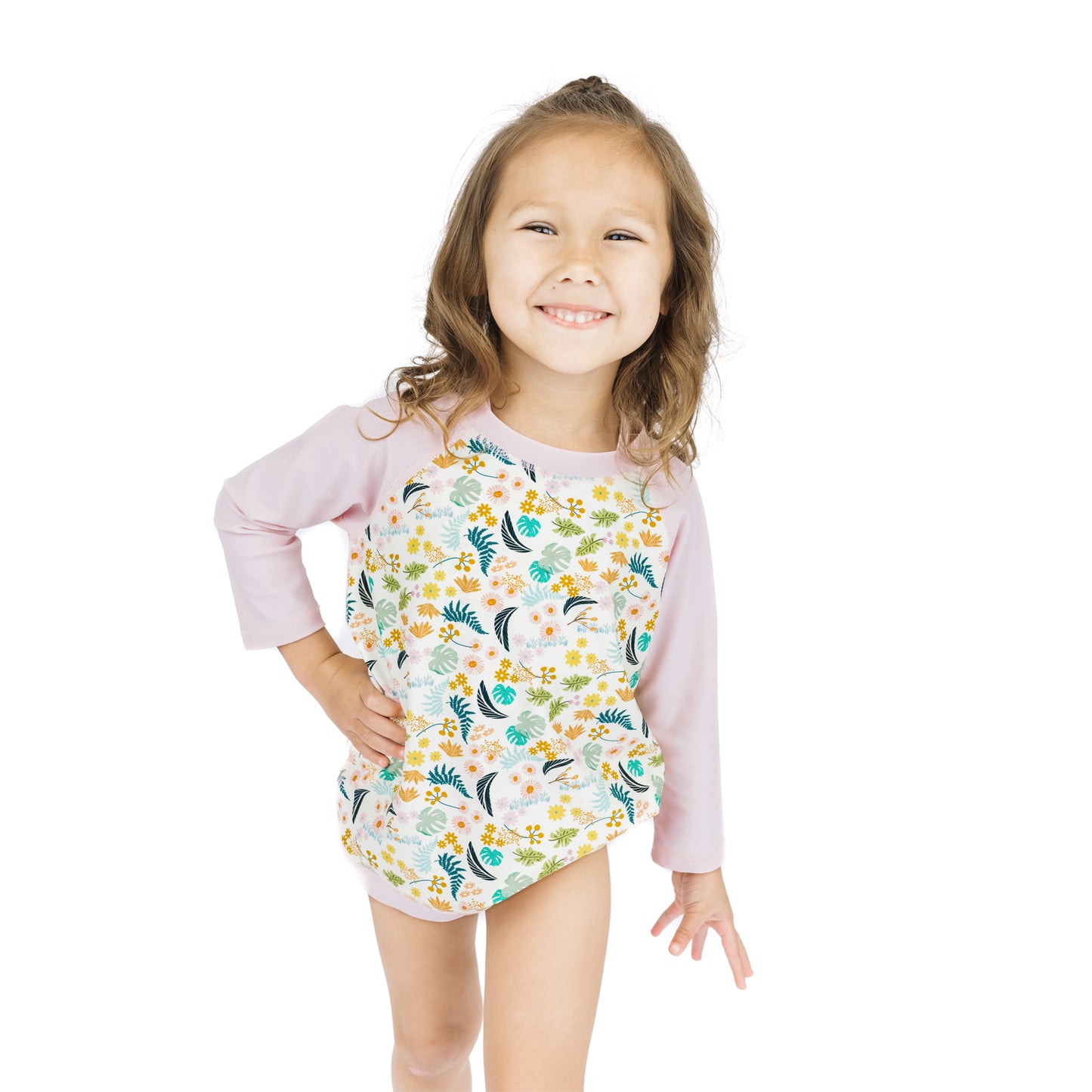 Young girl smiling while wearing the Tropical Blooms baseball rash guard shirt, showcasing the sporty and playful floral design.