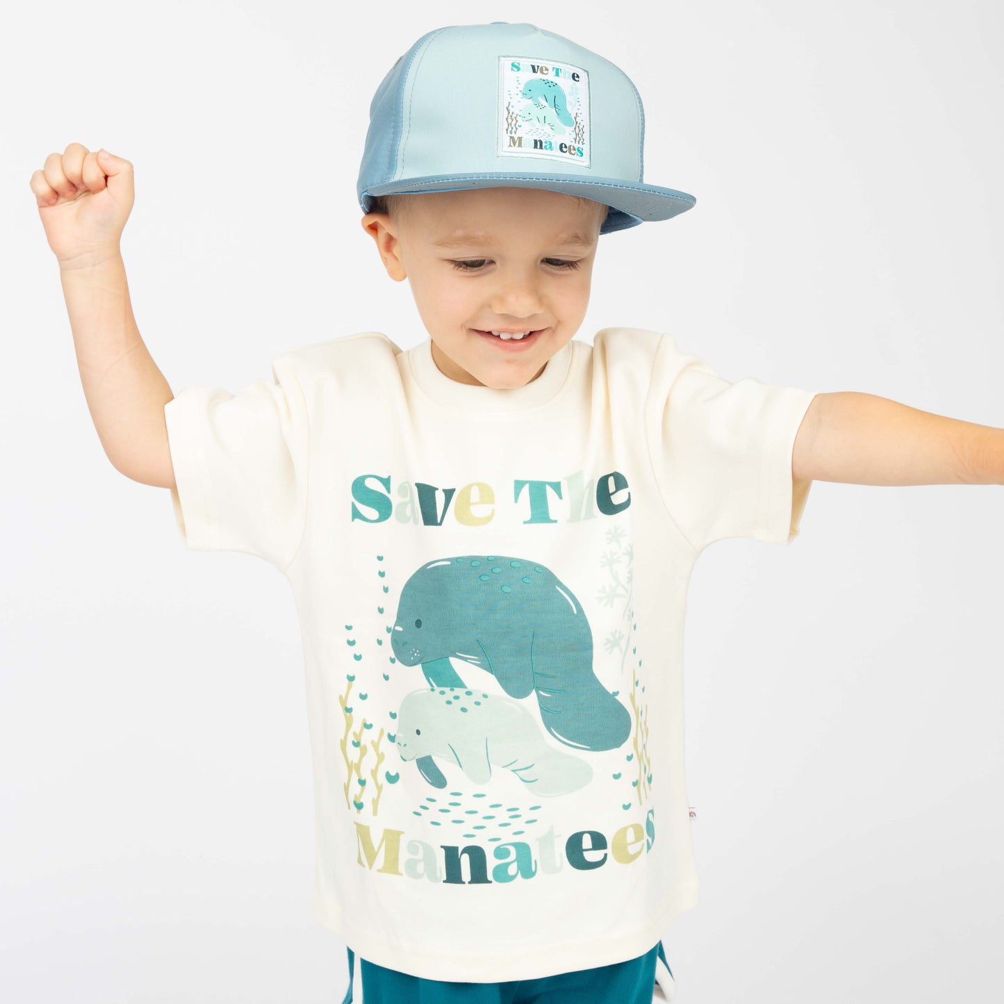 Little boy wearing our Save the Manatees Cotton Toddler Short Sleeve Shirt along with our Save the Manatee Snap Back.