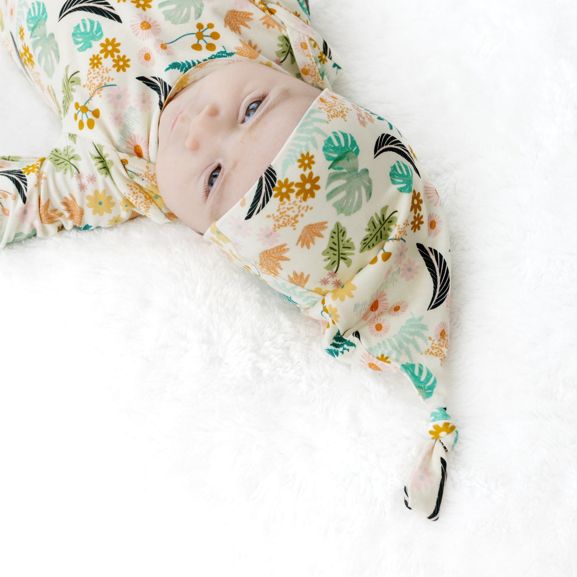 Close-up of a newborn in the Tropical Blooms tie-gown, highlighting the gentle, moisture-wicking fabric for sensitive skin.