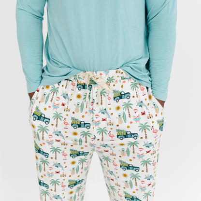 Person wearing light blue long-sleeve top and patterned pajama pants with tropical design.