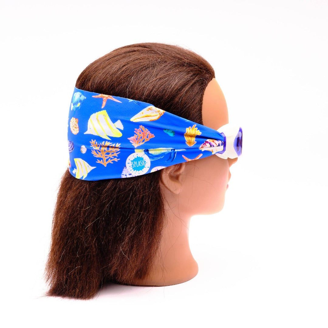 Swim goggles with a blue sea life scene on the strap on the head of a female mannequin