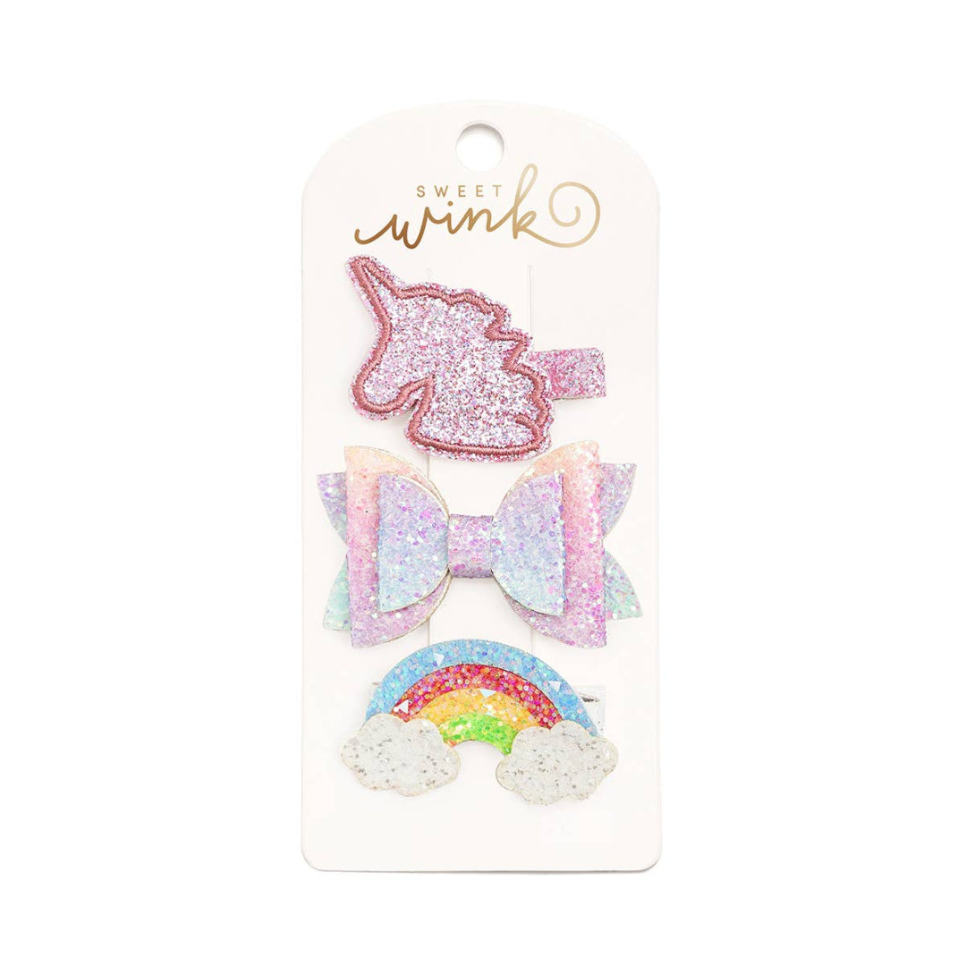 set of 3 glittery hair clips that include a unicorn clip, a multi colored bow, and a rainbow clip