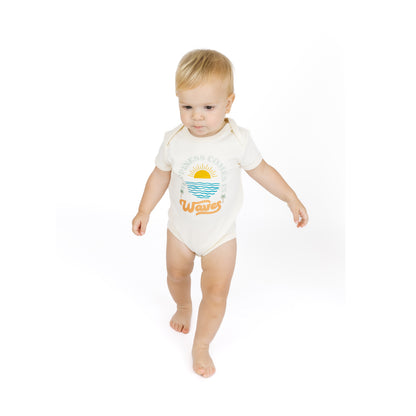 Baby wearing a white bodysuit with a graphic design on a white background