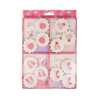 Packaged floral-themed notepads with decorative designs on a white background