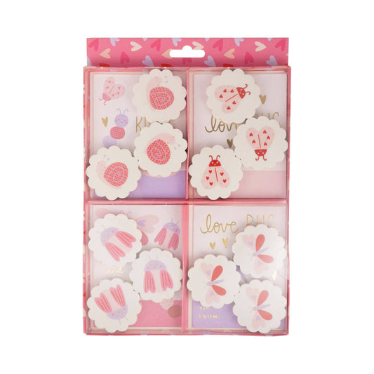 Packaged floral-themed notepads with decorative designs on a white background