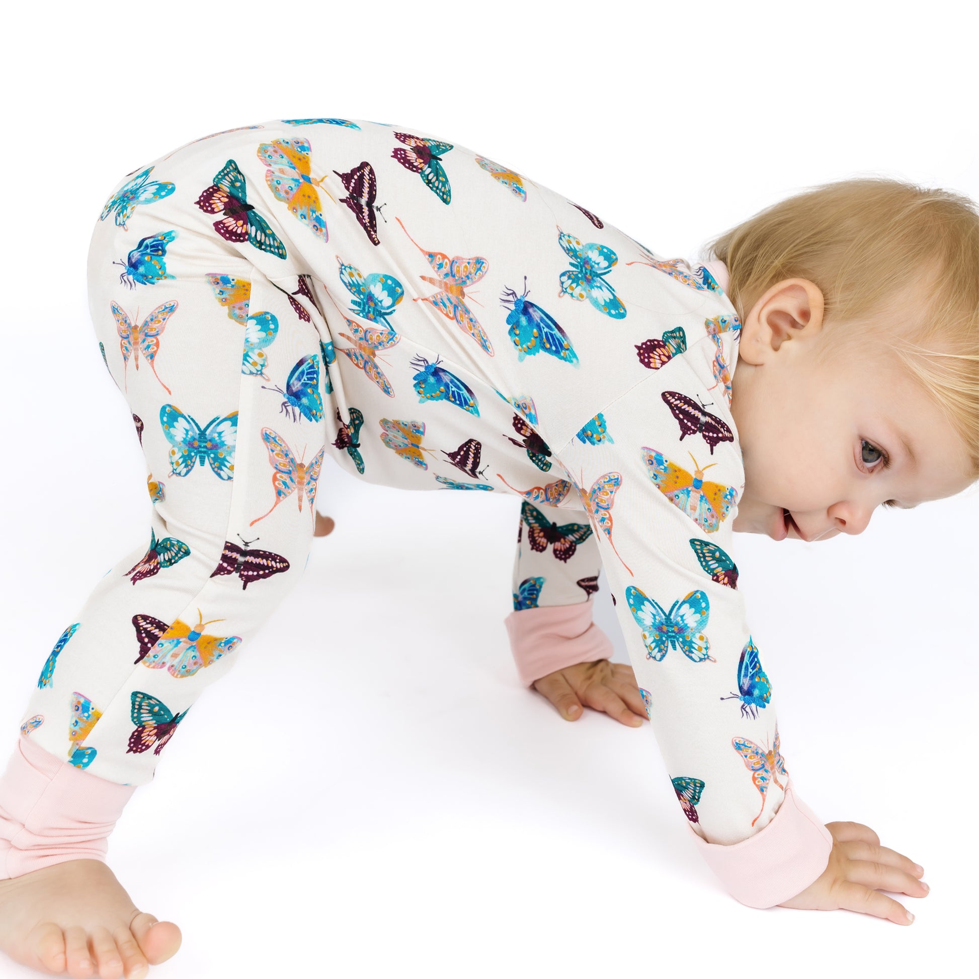 Child wearing a colorful butterfly-patterned outfit on a white background