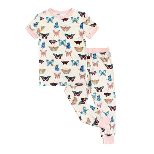 Two-piece kids short sleeve bamboo pajama set featuring a colorful butterfly print on a cream background.