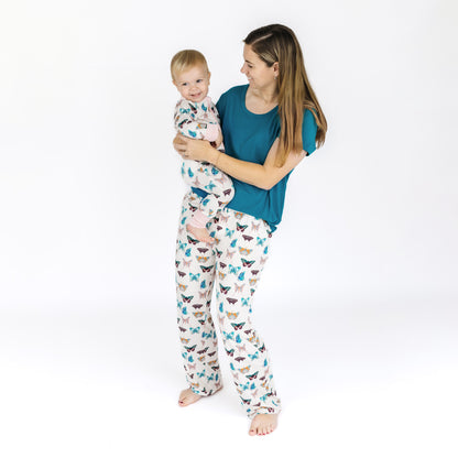 Woman and child wearing matching pajamas with a white background