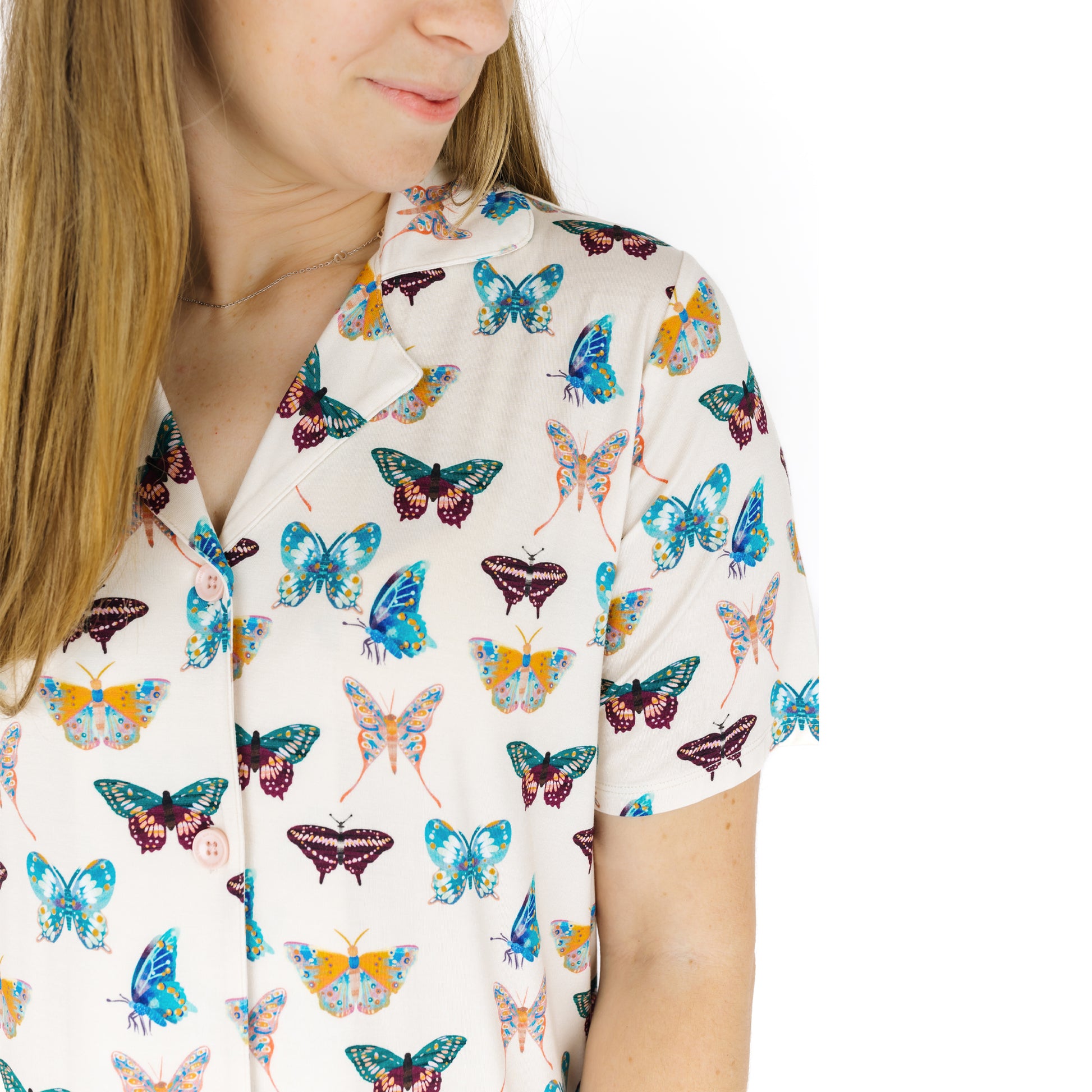 Woman wearing a nightgown with colorful butterfly pattern on a white background