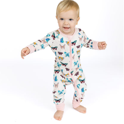 Baby wearing a butterfly-patterned onesie on a white background