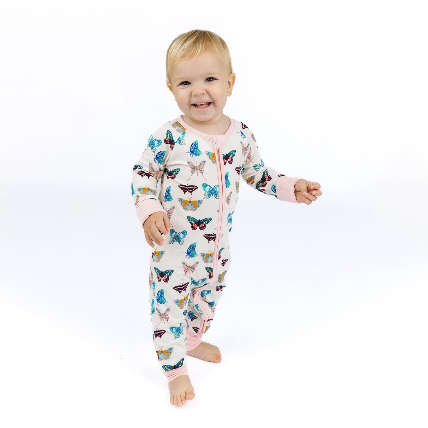 Baby wearing a butterfly-patterned onesie on a white background