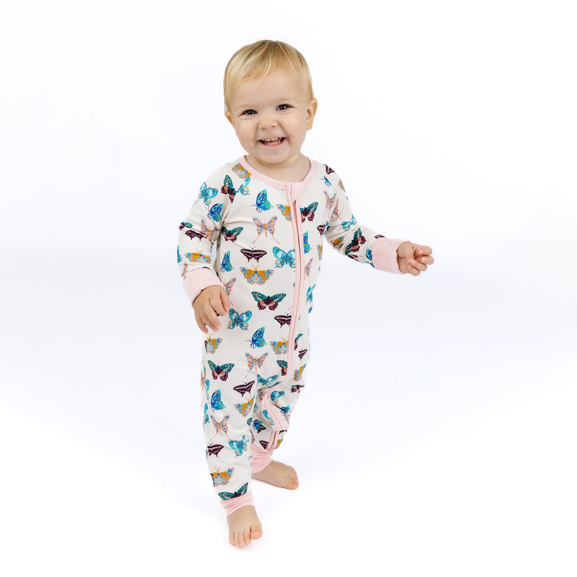 Baby wearing a butterfly-patterned onesie on a white background