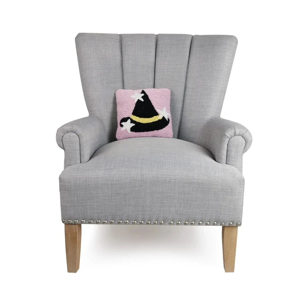 decorative chair with a pink halloween pillow with a black witch hat on it 