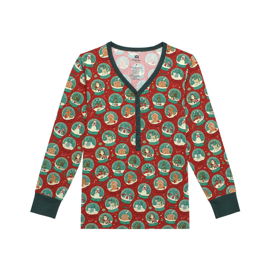 A long-sleeve V-neck pajama top with a festive Christmas print, featuring circular snow globe motifs on a red background with dark green trim and cuffs.