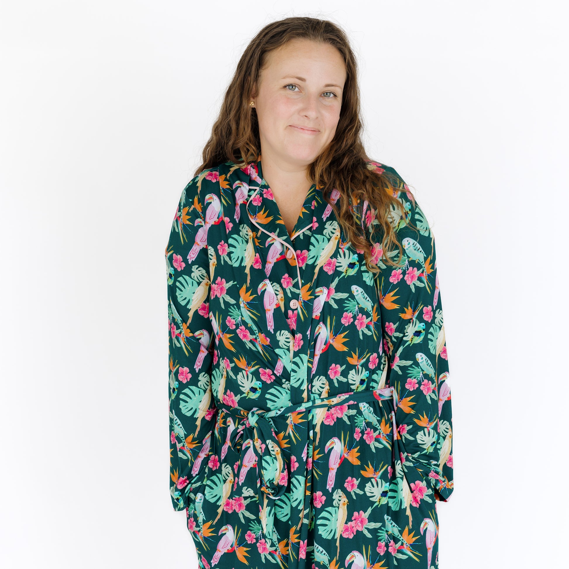 A woman smiling while wearing the Isla Botánica luxury robe, highlighting the vibrant colors and soft, breathable bamboo fabric.