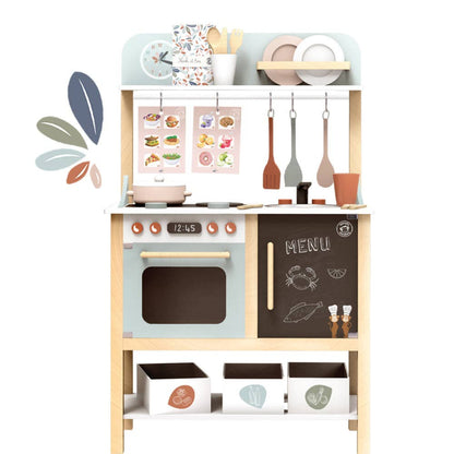 a wooden play kitchen in multi pastel colors and has accessories included such as pans, cooking utensils, plates, and cups. the kitchen has a pretend sink, cook top, and oven.