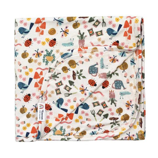 Flat lay bamboo hypoallergenic blanket on a white background. Showcasing the Garden Friends collection.