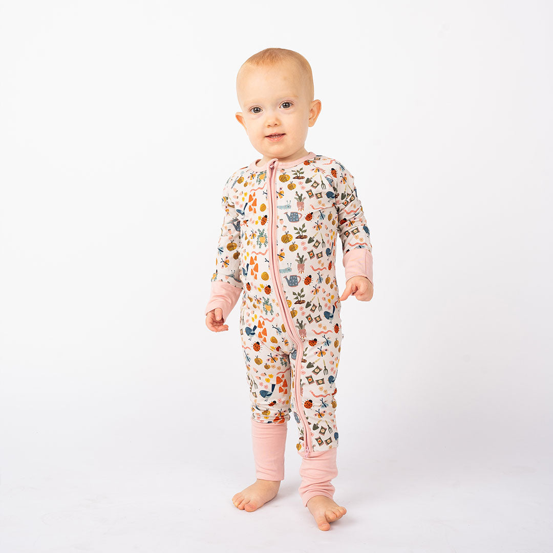 Baby showcasing our convertible Garden Friends pajama. The print showcase ladybugs, butterflies, flowers, birds, snails, cactus, bees and plants. 