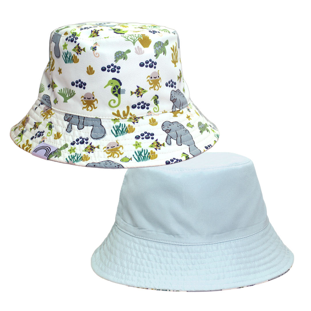 Two bucket hats, one with a colorful animal pattern and the other plain light blue, on a white background.