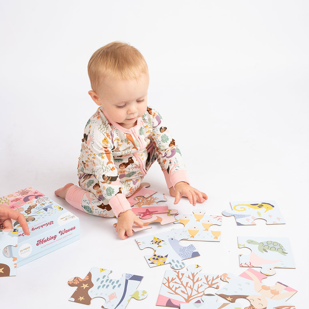 small baby in the "making waves" convertible, plays with the "making waves" puzzle. 