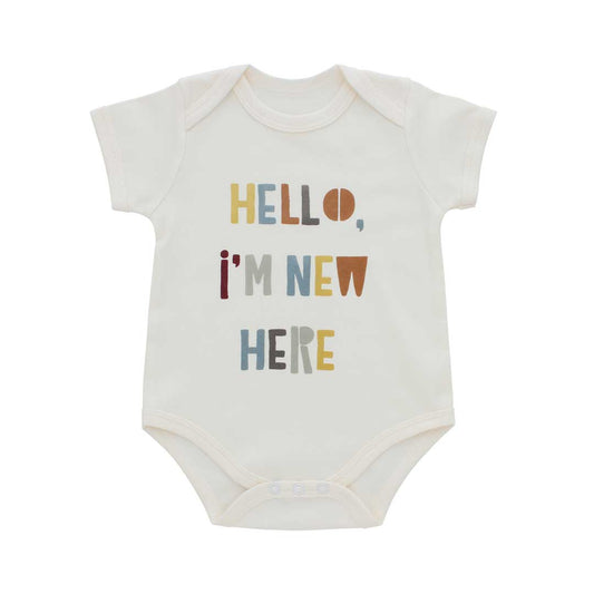 An off-white short-sleeve baby bodysuit with the text 'HELLO, I'M NEW HERE' printed on the front in a multicolor retro font, shown against a plain white background.